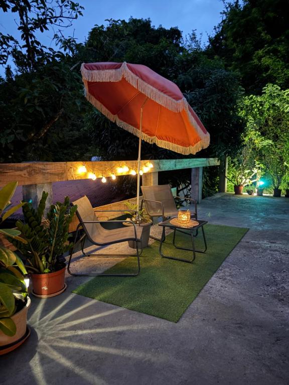 a patio with an umbrella and chairs and a table at Bas de villa Kay Lanati in Le François