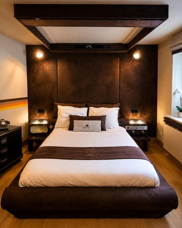 a bedroom with a large bed and a window at Chez Claude - Retro Chic Suite in Charleroi