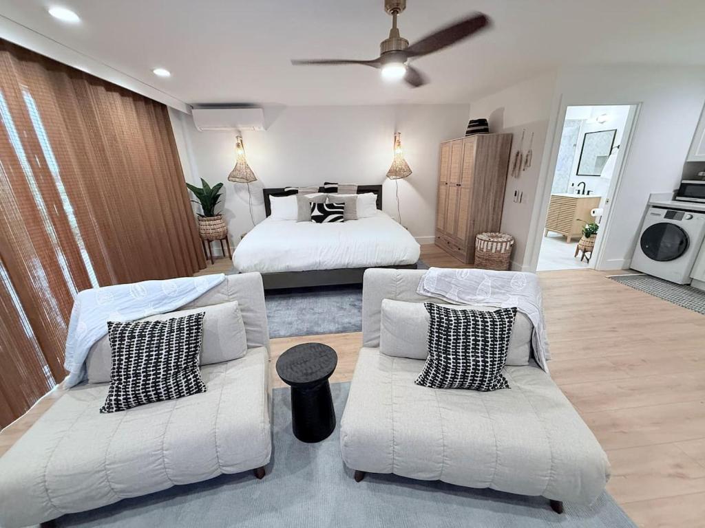 a bedroom with two beds and a couch and a tv at Kona Hang Loose Studio in Kailua-Kona