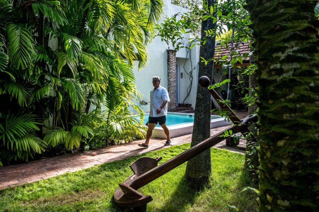a man walking by a pool in a yard at Casa De Columnas in Cartagena de Indias
