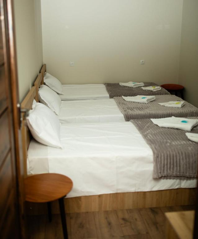 two beds in a room with white sheets and pillows at NIISS house in Akhaltsikhe