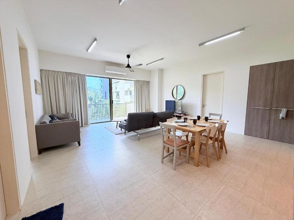 a living room with a table and a couch at By The Sea - UBTS SMART ENTERPRISE in Batu Ferringhi