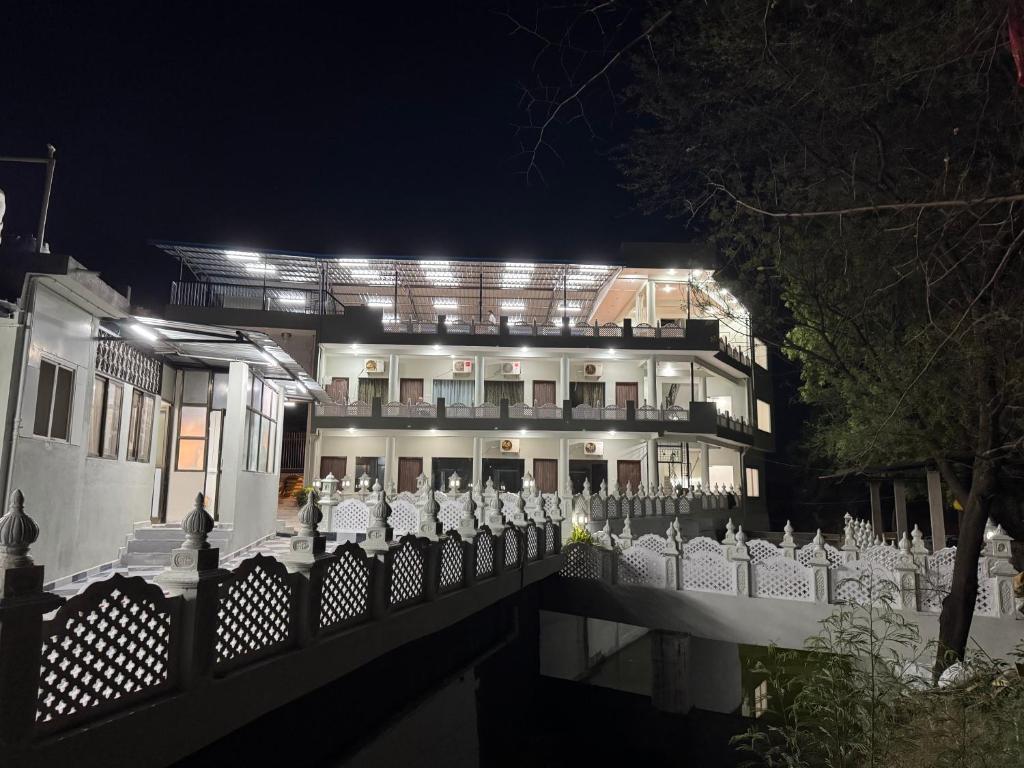 a building with a fence in front of it at night at Neem Tree Farm Stay in Ujjain