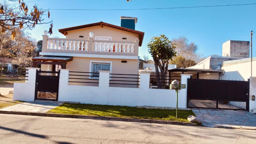 a house with a white fence in front of it at Mí cielo in Huerta Grande