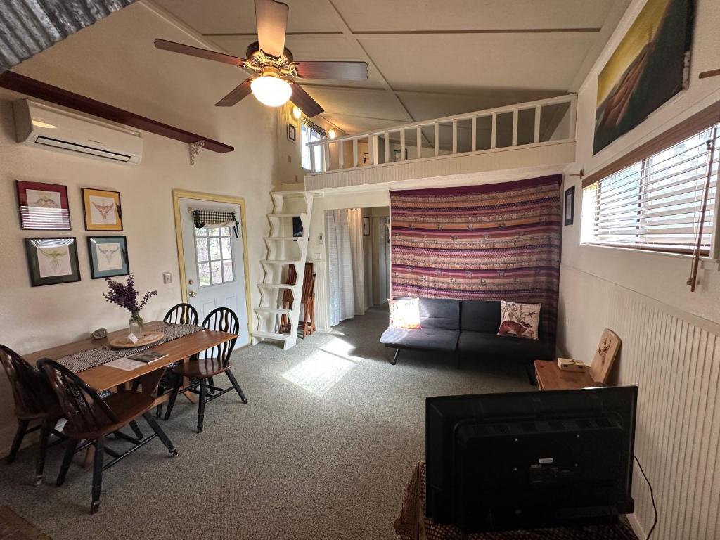 a living room with a table and a couch and a television at The Lake House in Weed