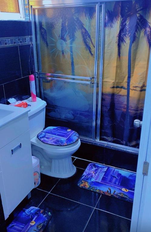 a bathroom with a toilet and a shower with palm trees at Villa panamericana in El Seis