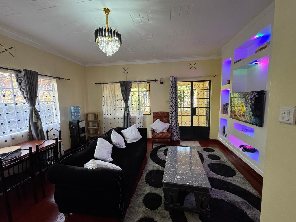 a living room with a black couch and a table at The Mimaced Homes in Homa Bay