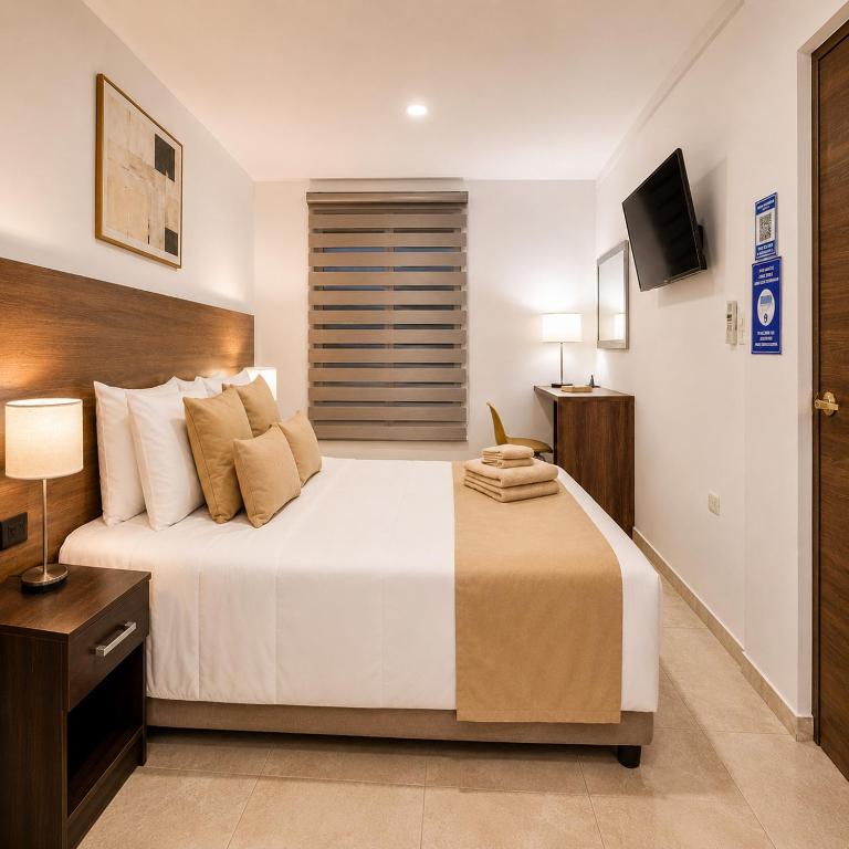 a bedroom with a large bed and a television at Plaza Lobos in Puerto Baquerizo Moreno