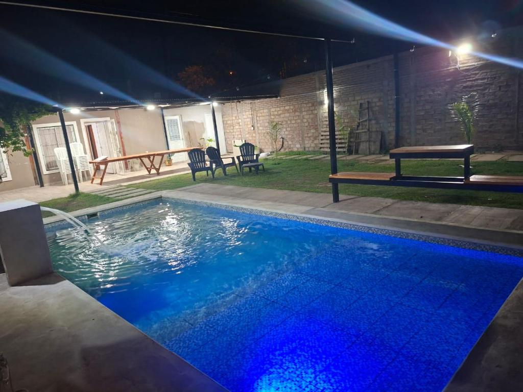 a swimming pool at night with a picnic table at Finca El Algarrobo, confort y excelente ubicación in Santiago del Estero