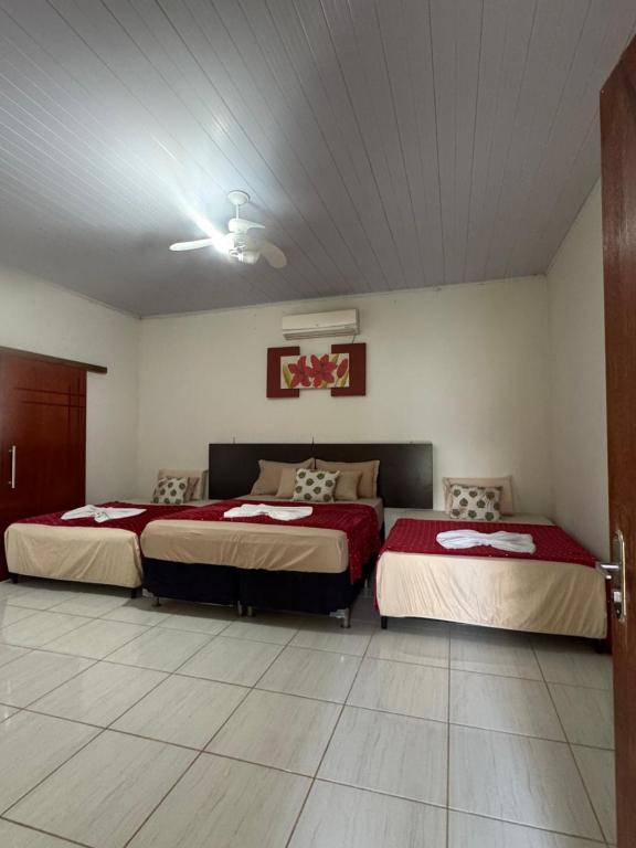 a bedroom with two beds in a room at Refúgio Mix Pousada com 3 suítes e 9 camas in Vilhena