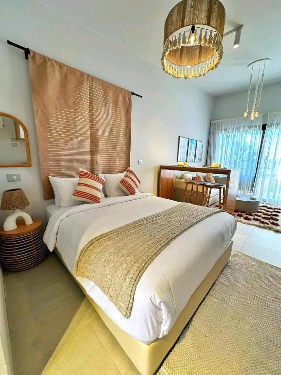 a bedroom with a large bed and a chandelier at قرية بلوباى مرسي مطروح in Marsa Matruh