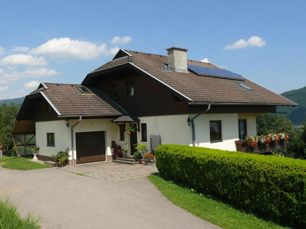 ein Haus mit einem braunen Dach und einer Auffahrt in der Unterkunft Ferienwohnung Eichler in Feldkirchen in Kärnten