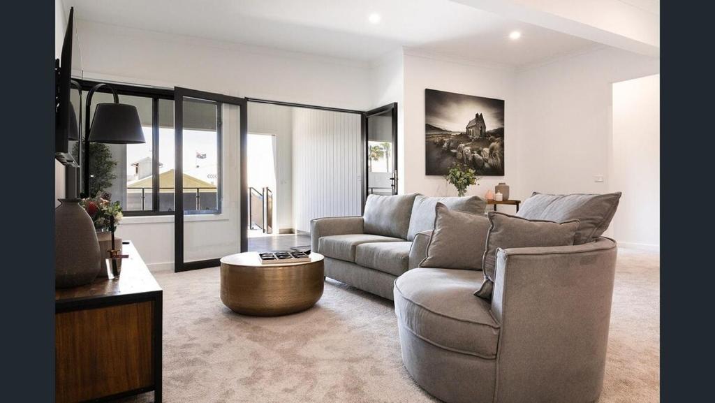 a living room with a couch and a table at The Lime Loft, Rooftop Views in Mildura's CBD in Mildura