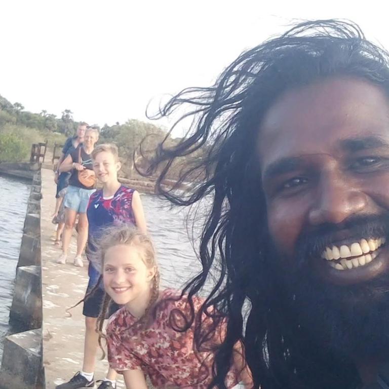 a man and a little girl standing in the water at Nimal's white house in Nilaveli