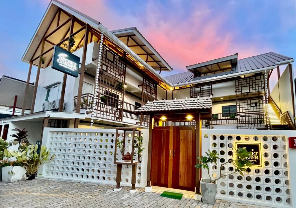 a house with a red door and a white fence at Secret Corner Boutique Stay in Chiang Rai