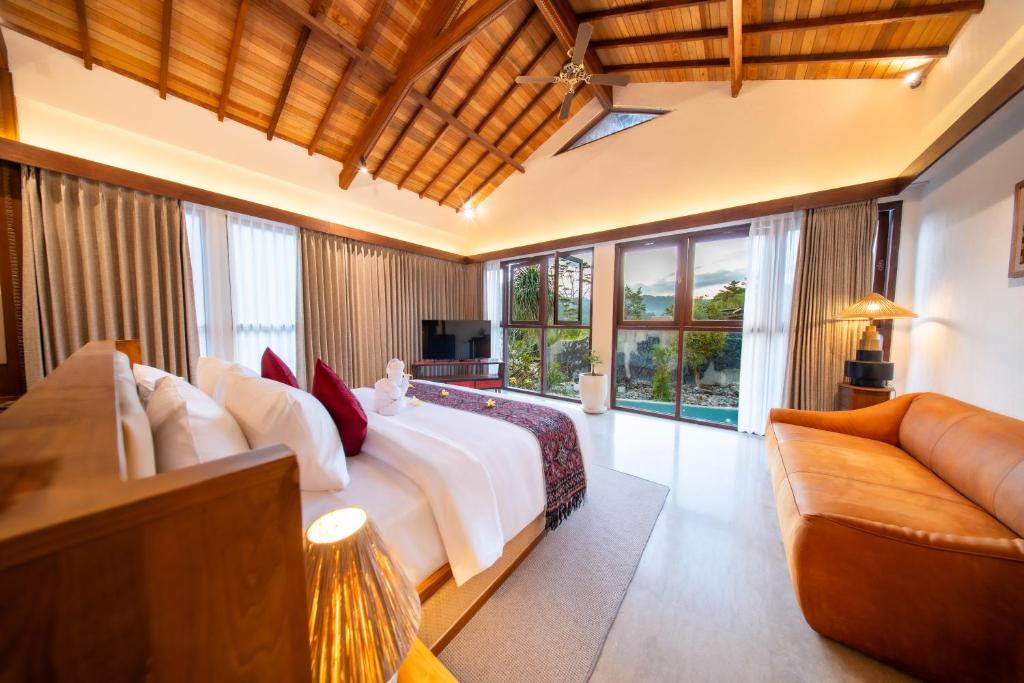 a bedroom with a large bed and a couch at Kropak Sidemen in Sidemen