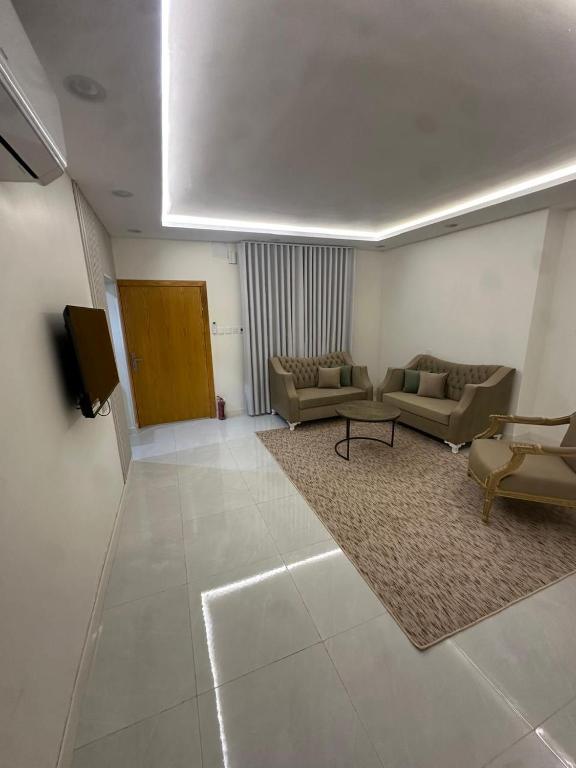 a living room with two couches and a tv at شقة غرفة وصالة in Musaylah