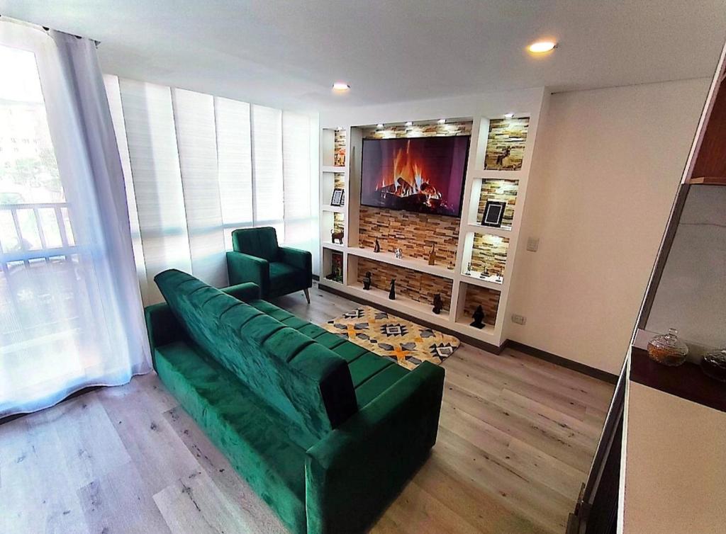 a living room with a green couch and a tv at Faro 4, Jaime Duque, Autódromo Tocancipá in Tocancipá