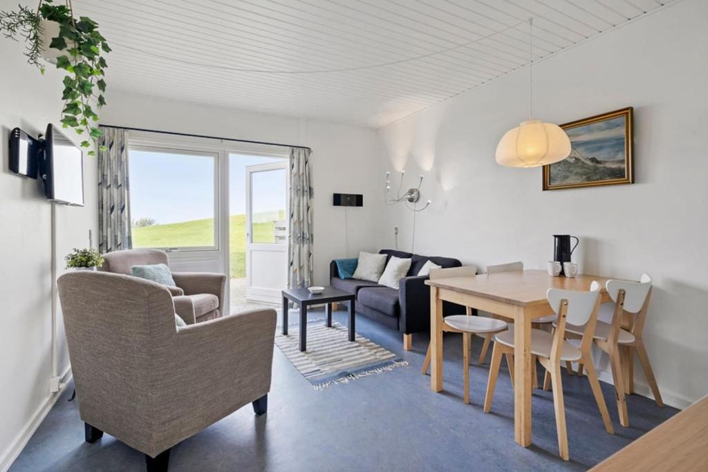 a living room and dining room with a table and chairs at Sct Knudsborg - 12C - Apartment on the beach in Brenderup