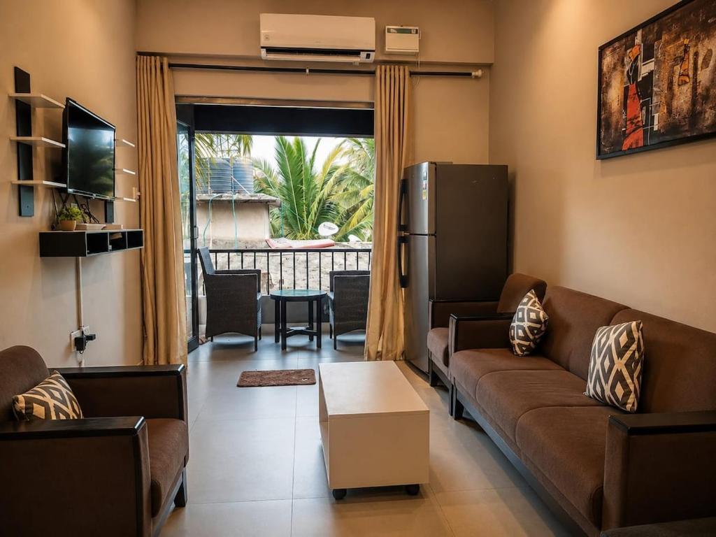 a living room with a couch and a refrigerator at Goan Casa Feliz in Calangute
