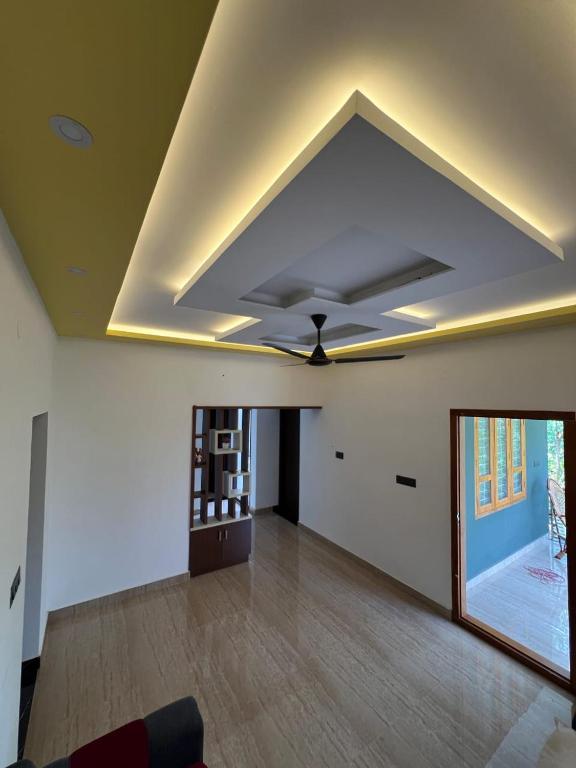 a living room with a ceiling with a fan at Kurishingal Guest House in Mararikulam