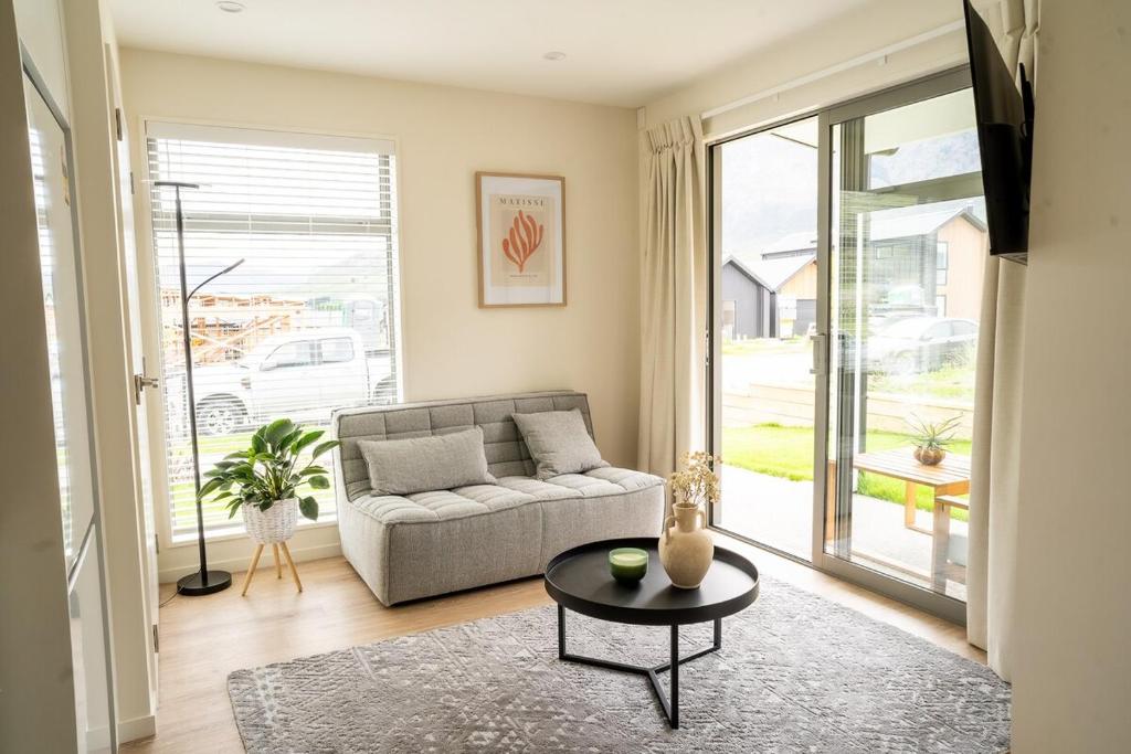 a living room with a couch and a table at Southern Peaks Hideaway in Queenstown Airport