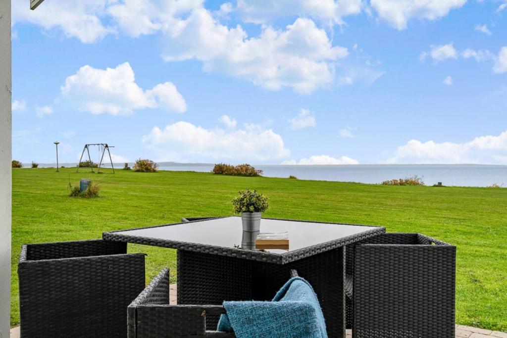 a table and chairs with a view of a field at Sct Knudsborg - 12H - Summerhouse on the beach in Brenderup