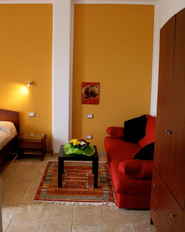 a living room with a red couch and a table at Villa Liburnia in Livorno