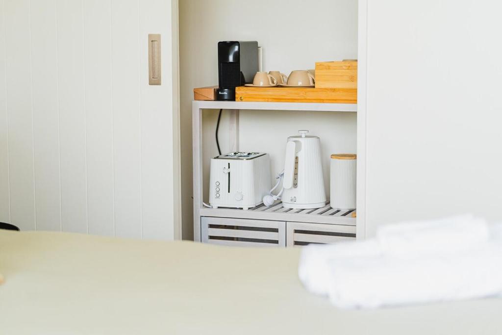 a kitchen cabinet with a coffee maker on a shelf at Southern Peaks - Private Room in Queenstown Airport