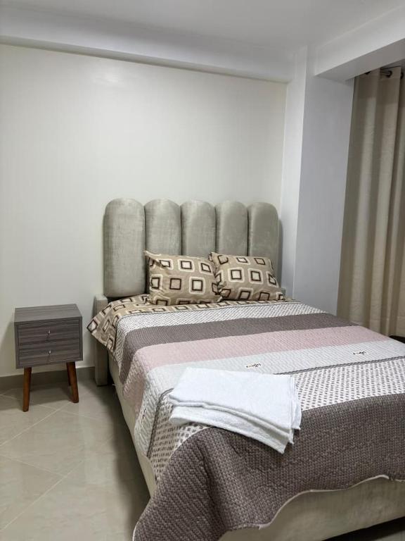 a bedroom with a large bed with a gray headboard at Habitación completa in Huaraz