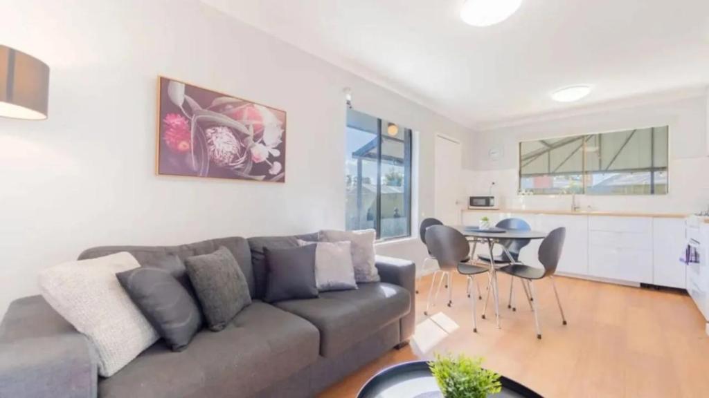 a living room with a couch and a table at Nouveau Home in Epsom