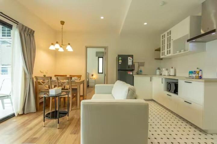 a living room with a white couch and a kitchen at Title Naiyang Walk To Beach C111 in Nai Yang Beach