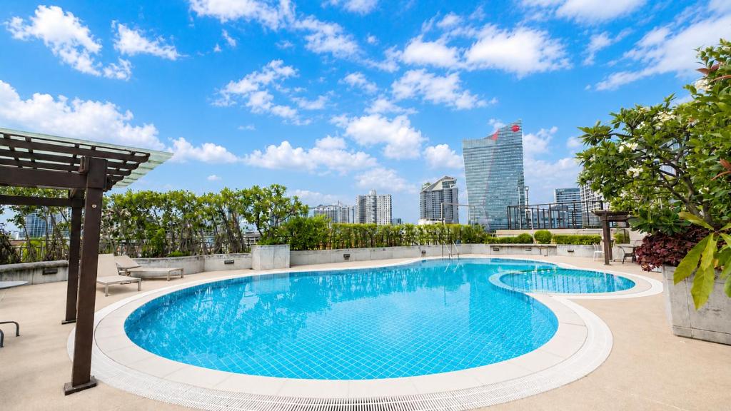 a swimming pool with a city skyline in the background at Olive Hotel & Residence Bangkok Sukhumvit 101 near True Digital Park in Bangkok