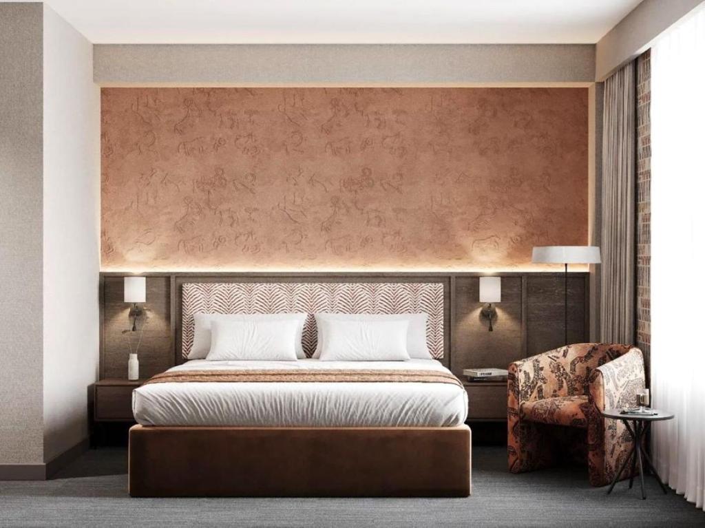 a bedroom with a large bed and a chair at Urban Hotel Ethno in Bishkek