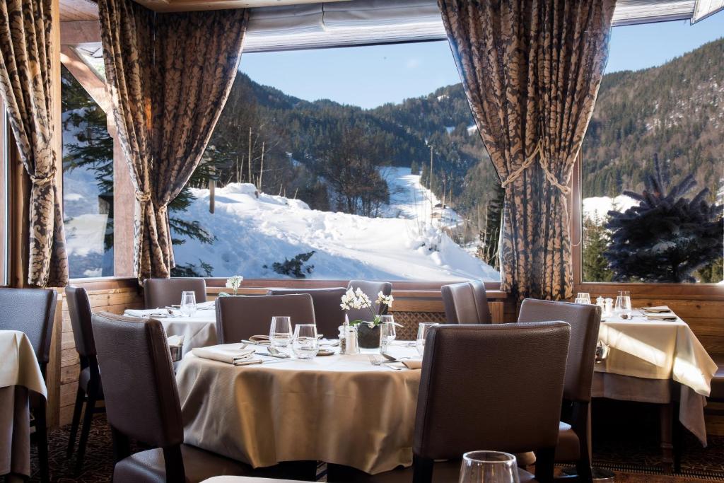 a restaurant with a view of a snow covered mountain at Hotel Beauregard in La Clusaz