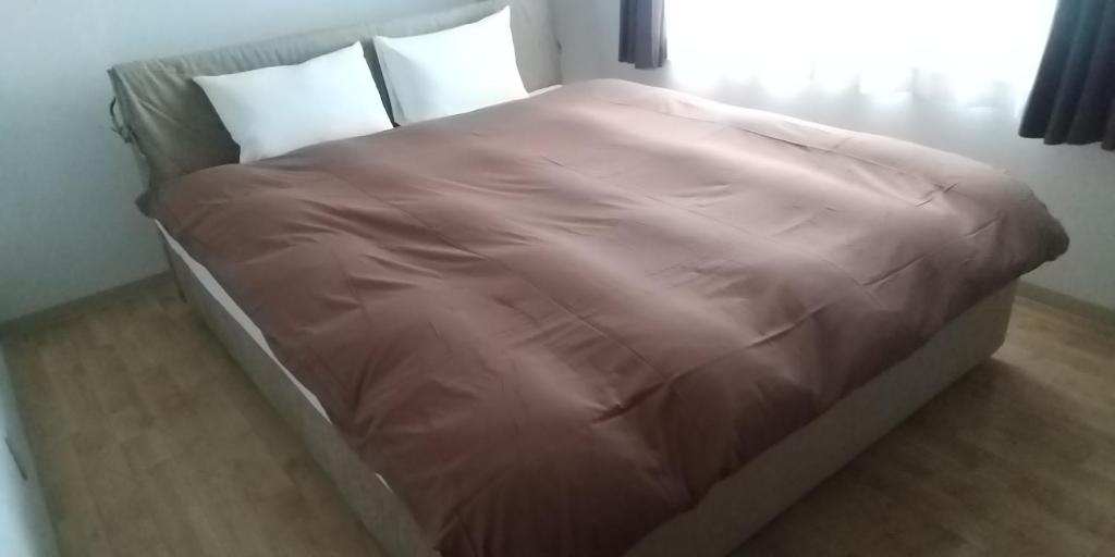 a bed with a pink blanket on it in a room at メープル桑園駅202 in Sapporo