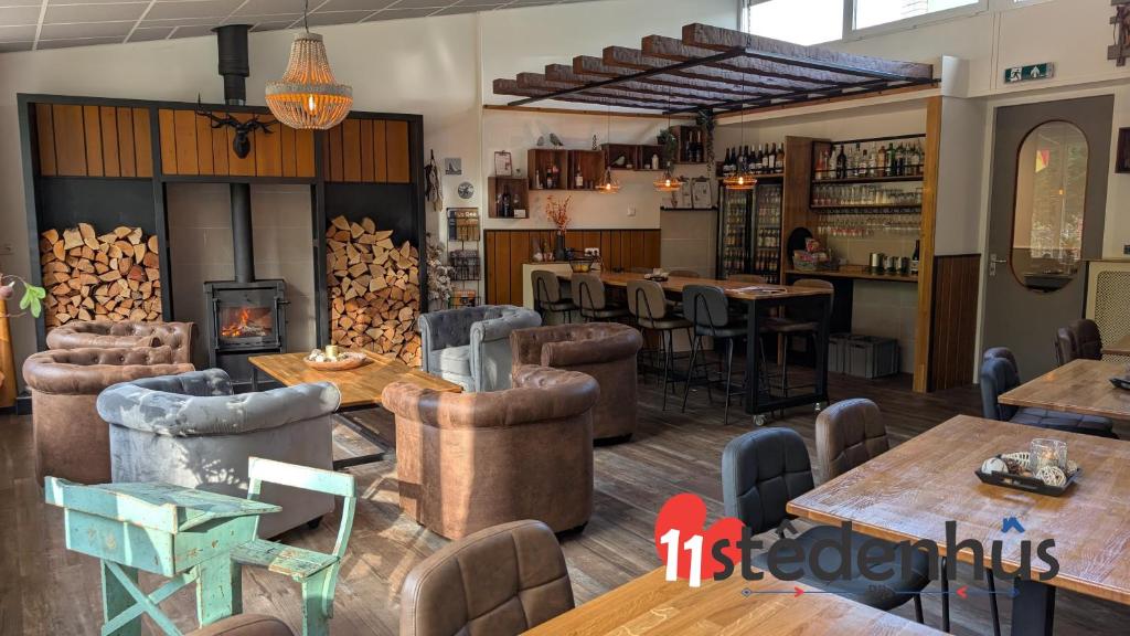 a restaurant with tables and chairs and a fireplace at 11Stedenhuis in Rijs