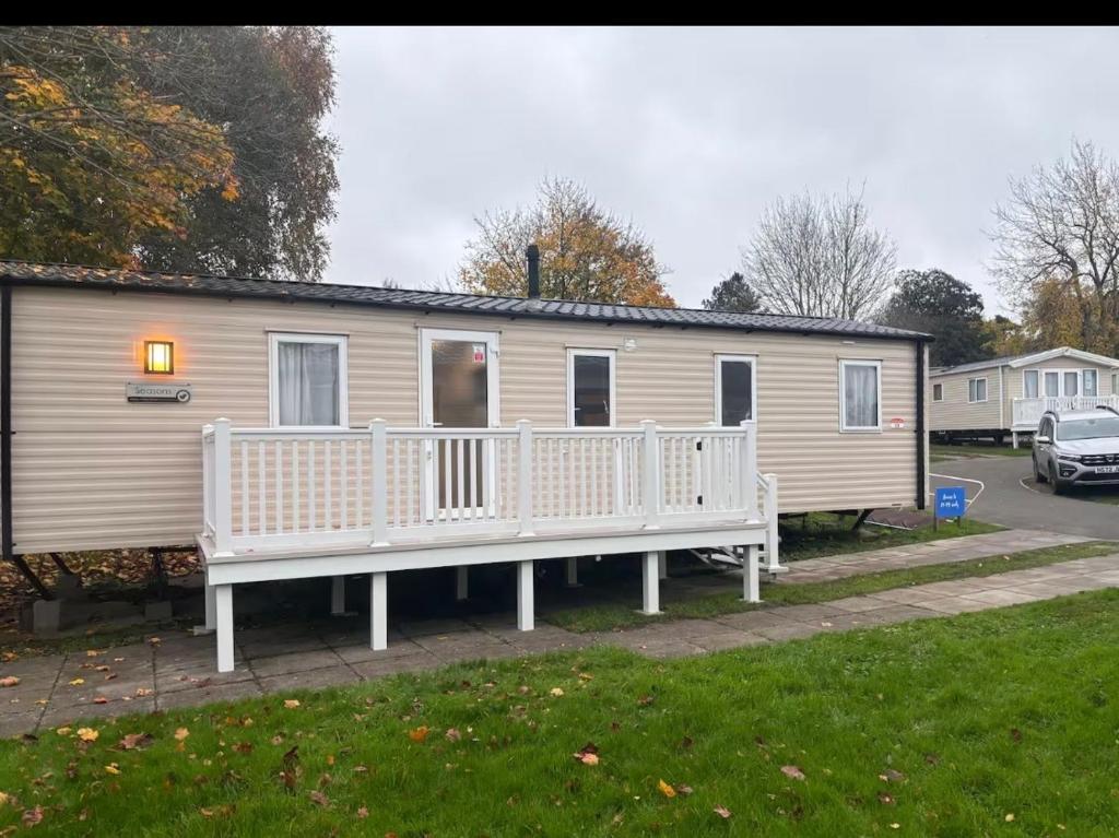 a mobile home with a porch and a bench at Explorer45 in Lytchett Minster