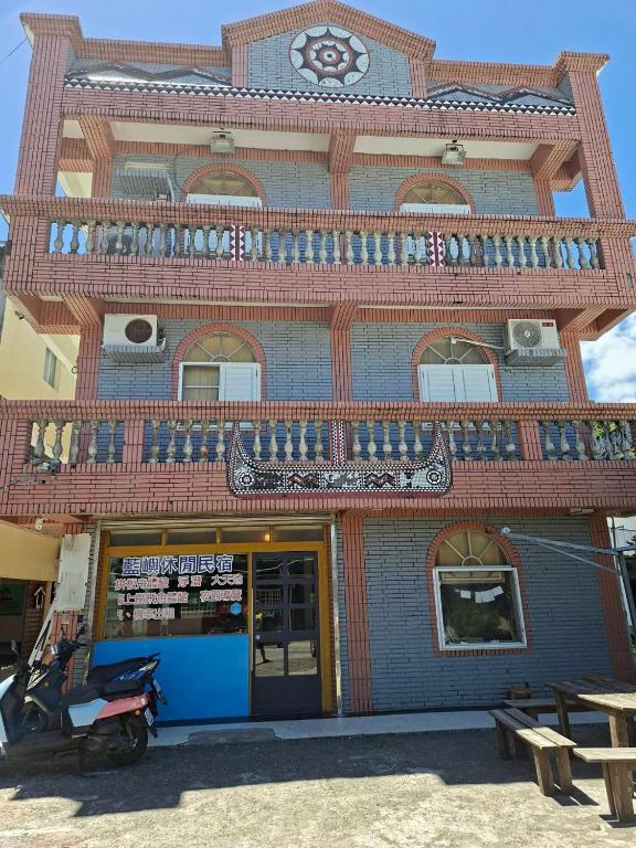 a building with a balcony and a scooter parked in front at 藍嶼休閒民宿 in Lanyu