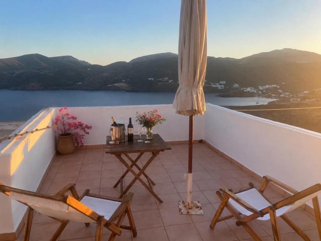 a balcony with a table and chairs and a view at The Red-Fish House in Astypalaia
