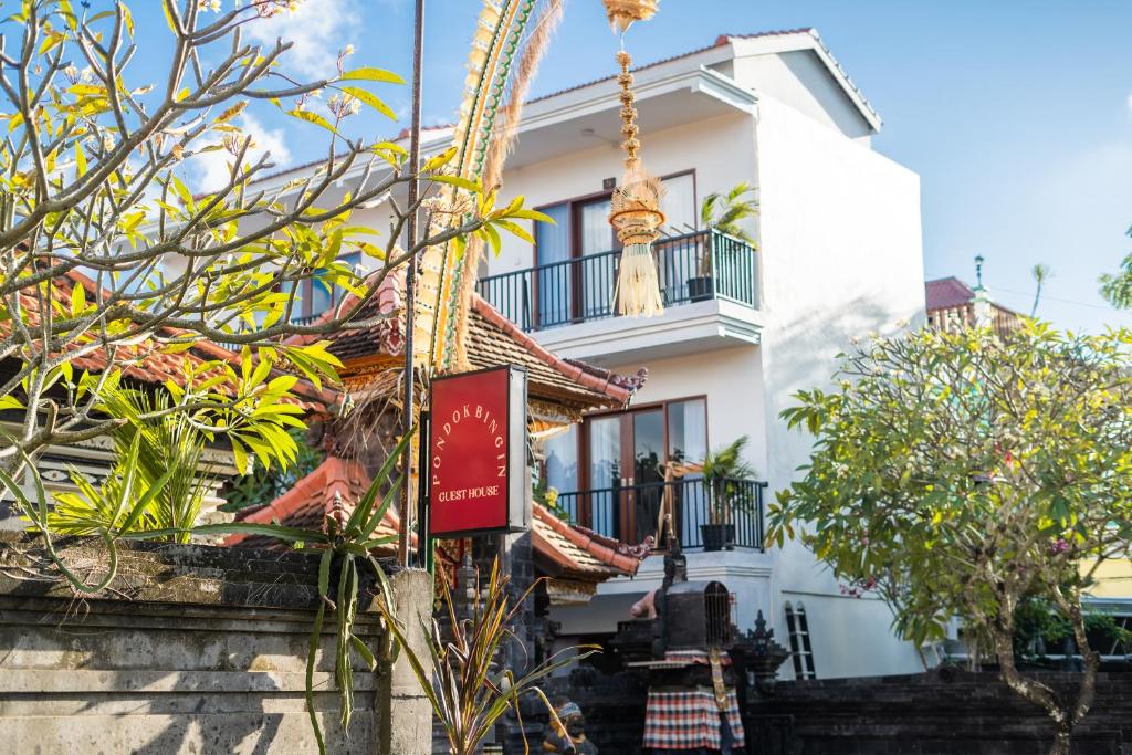 a white building with a sign in front of it at Pondok Bingin Guest House in Bingin Beach