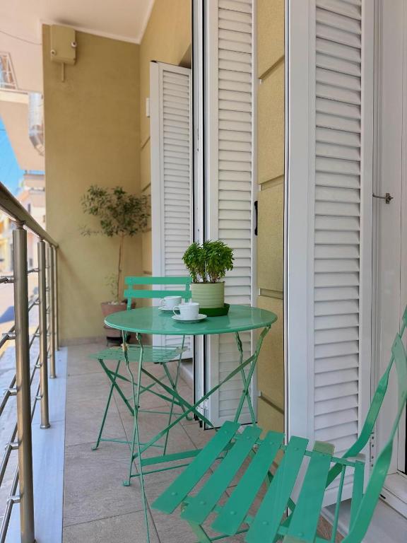 a green table and chairs on a balcony at Olivia 42 in Nafpaktos