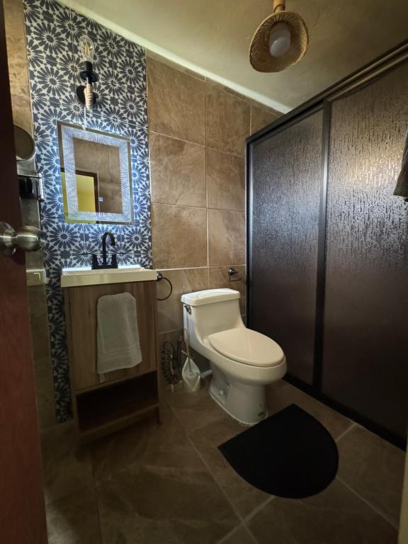 a bathroom with a toilet and a sink and a mirror at Casa MARTINA in Villahermosa