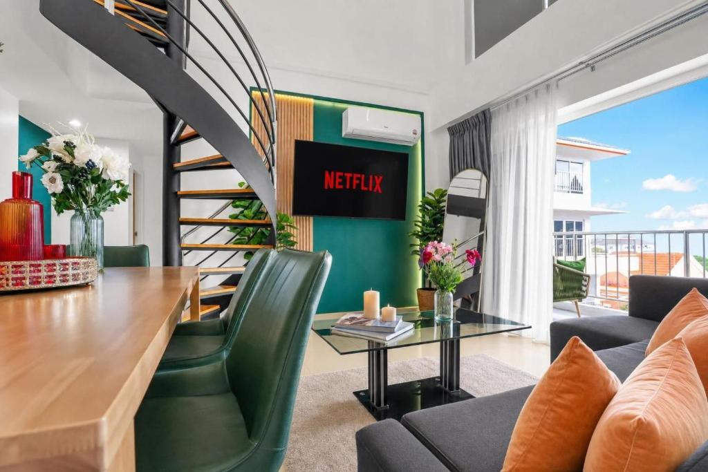 a living room with a table and a spiral staircase at Luxurious Penthouse Pattaya in Pattaya South