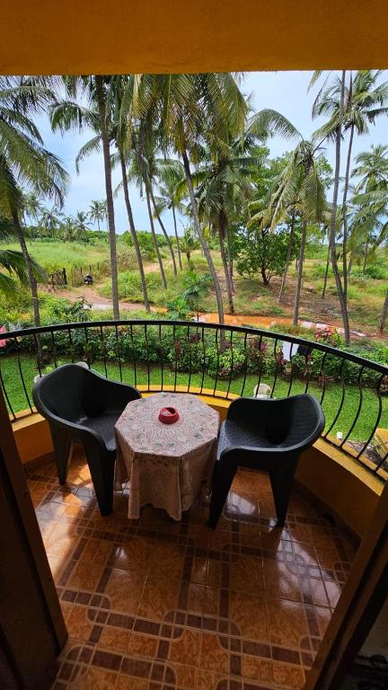 a room with a table and chairs and a balcony at Flobestian's Seafront Villa in Candolim