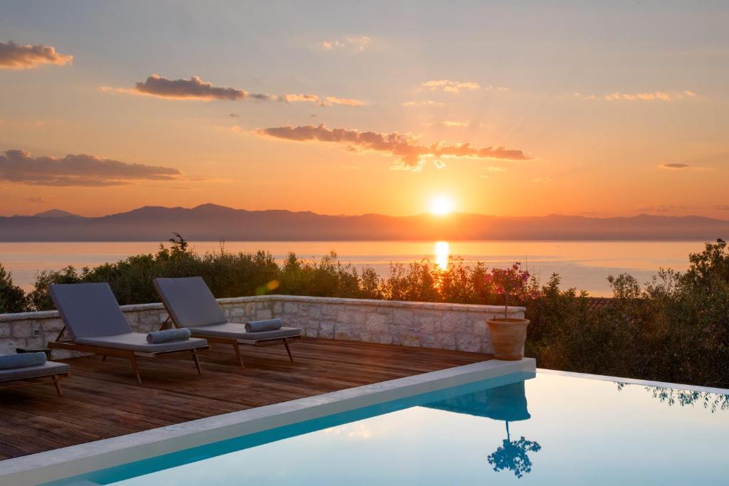 a pool with a view of the ocean at sunset at Villa Porto Mongonisi in Porto Ozias