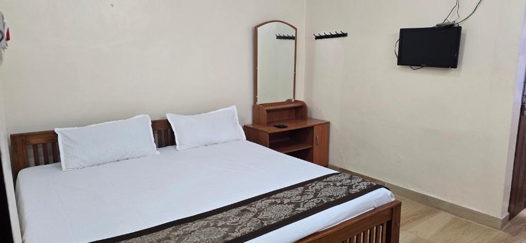 a bedroom with a bed with a mirror and a television at Kodai blue residency in Kodaikānāl