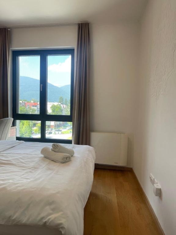 a bedroom with a bed and a large window at ilidza sky river 2 in Sarajevo