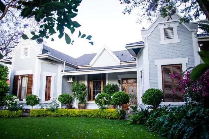 ein weißes Haus mit einem grünen Rasen davor in der Unterkunft Die Herehuis in Beaufort West