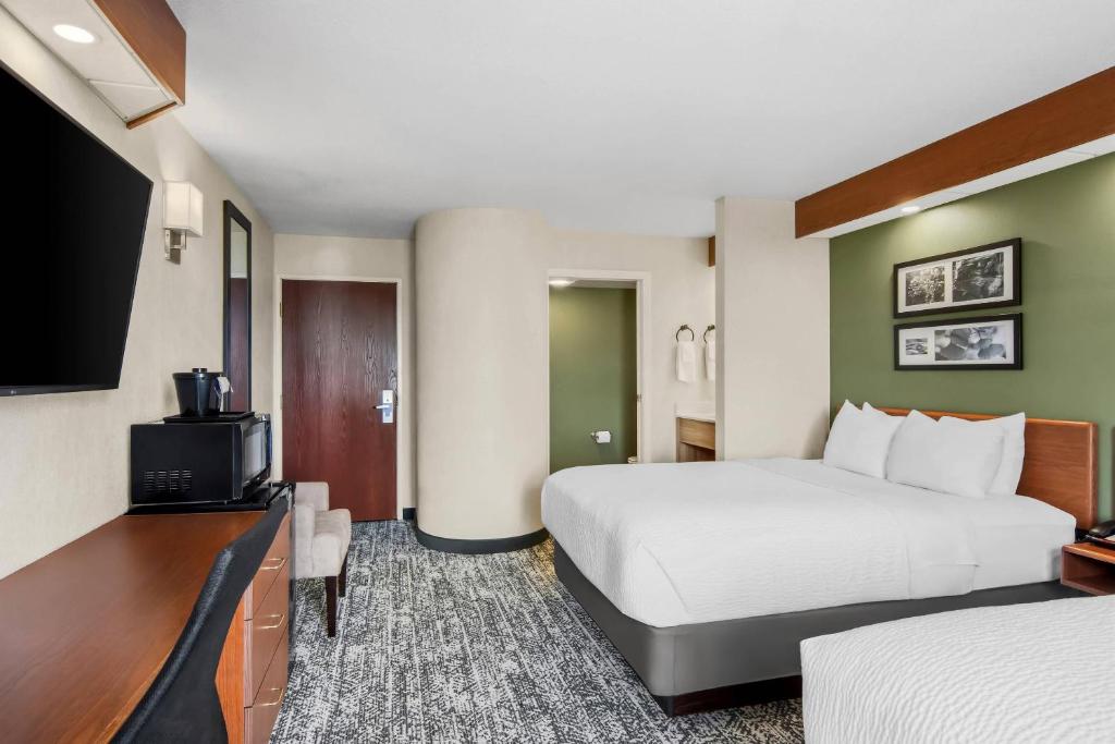 a hotel room with a bed and a flat screen tv at Sleep Inn & Suites Bay View Acme - Traverse City in Traverse City